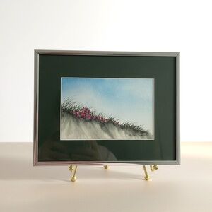 Framed watercolor beach scene, sand dunes with grass and pink flowers, signed
